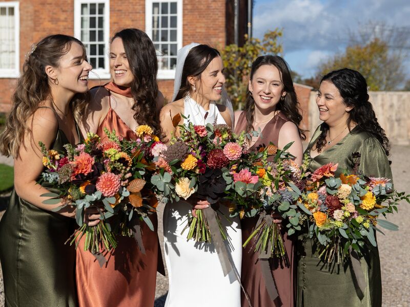 Ellie with her bridesmaids carrying wild autumn bouquets at Delbury Hall