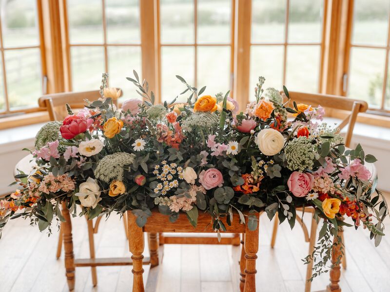 Colourful spring altar arrangement with pink, orange and yellow flowers at Hyde House