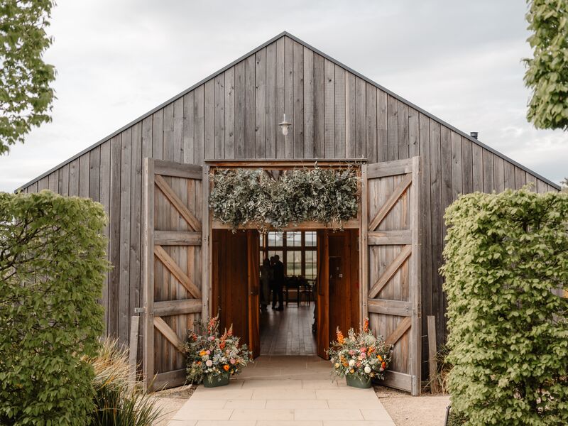 The Grange at Hyde House framed with olive foliage and colourful spring flowers