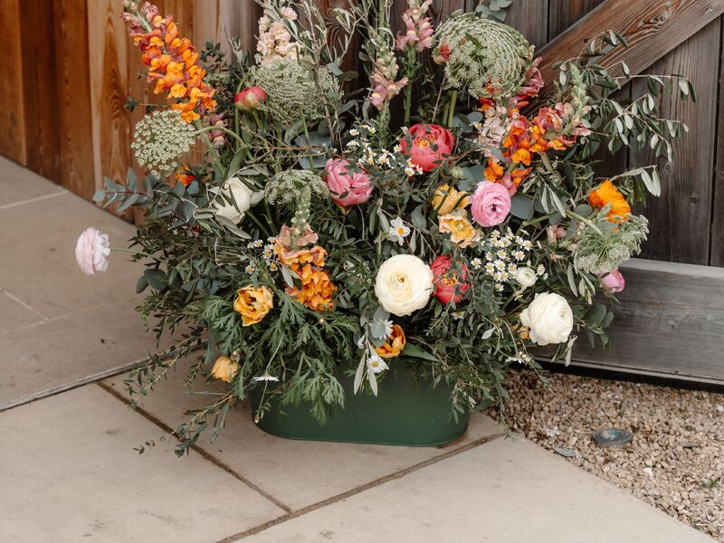 Spring flower floor arrangement beside the timber entrance to The Grange at Hyde House