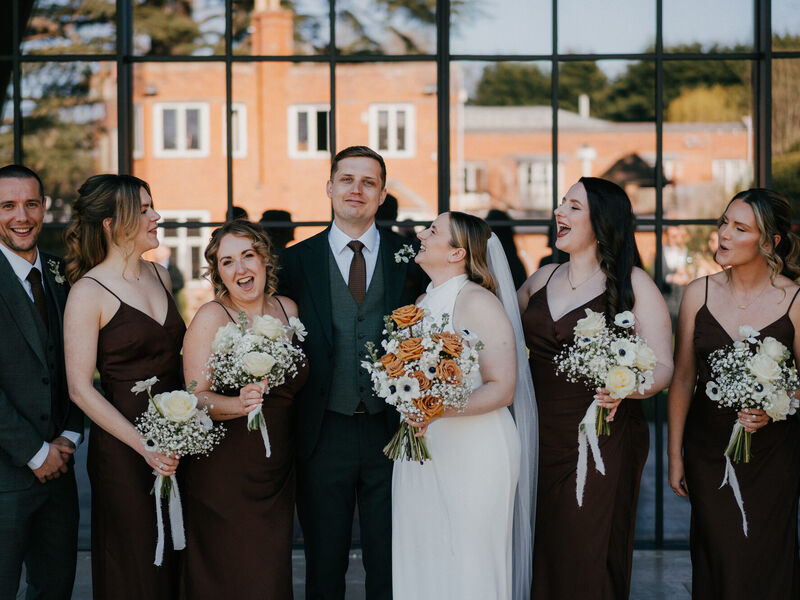 Sophie and Grant’s finished spring wedding flowers at The Post Barn — Photography by Linas Sophie and Grant laughing with their wedding party and white and toffee bouquets