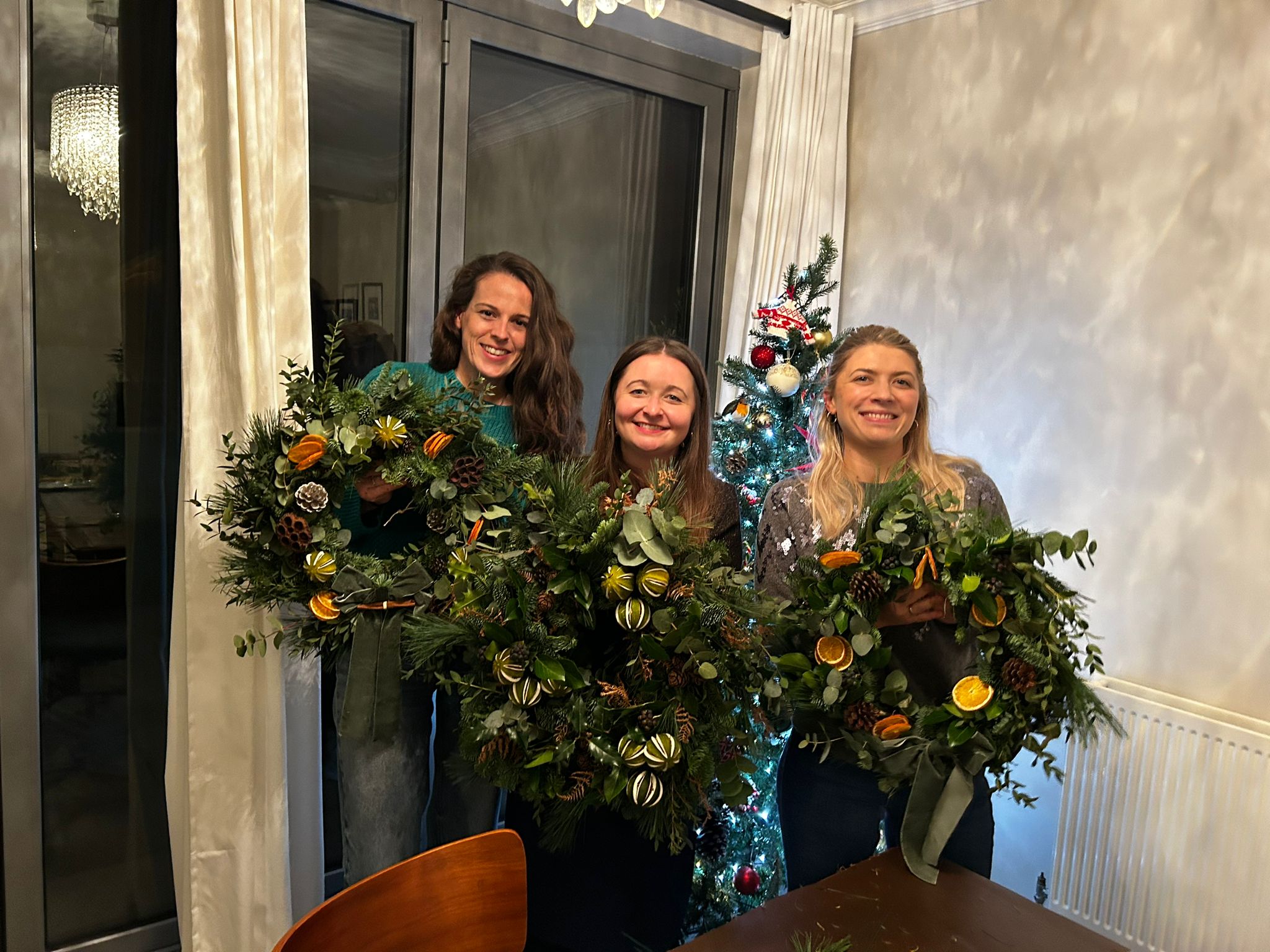 Guests holding finished natural Christmas wreaths