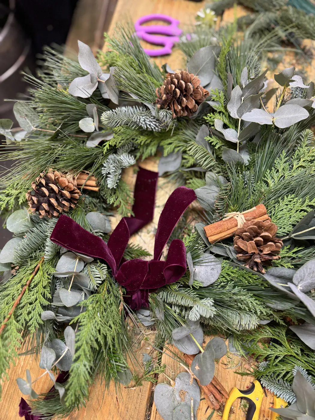 Natural evergreen Christmas wreath finished with pine cones and velvet ribbon